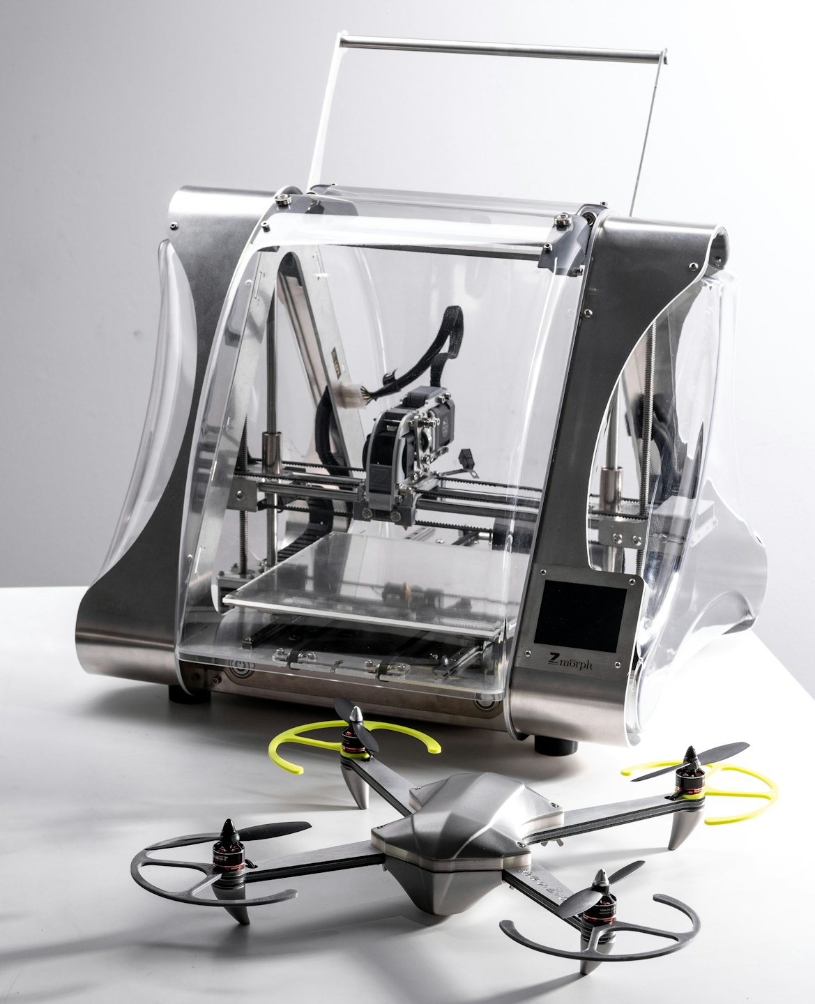 3D printer and a grey drone with yellow accents.