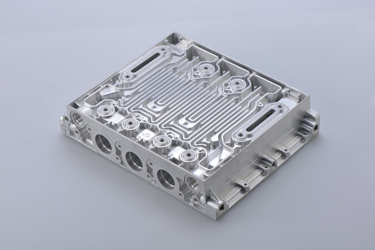 Precision machined aluminum heat exchanger with intricate channels and ports.